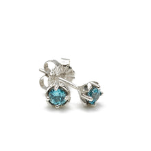Load image into Gallery viewer, A pair of Zircon Hexpetal Studs against a white surface. 4mm blue zircon gems nestled in a unique flower-inspired stud design with our trademark hexagonal accents, and featuring top quality natural blue zircon, these beautiful sterling silver earrings are a perfect way to show off your unique style.