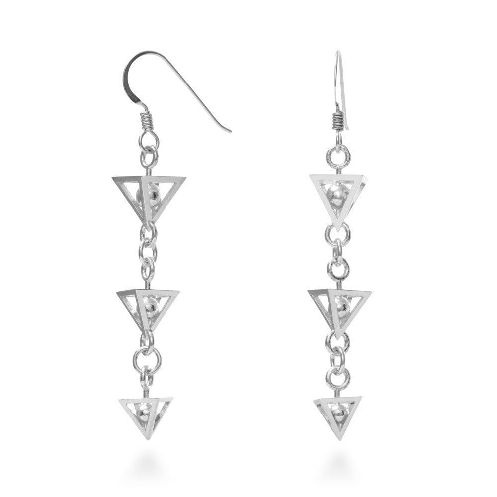 A photo of the Diminished Third Earrings, which are a flurry of motion at every turn. Three pentahedrons (square pyramids) of angled sterling, inside of each lies a captive sphere of silver. Each pentahedron diminishes in size down the 50mm length of the earring, and all three are joined together loosely to flow and twist and move, catching light and eyes everywhere you go. These come suspended from hypoallergenic Argentium silver hooks for added comfort and exceptional tarnish resistance.