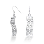 A pair of Hexwave Earrings hang in front of a white background. The sterling silver Hexwave earrings flow back and forth in a smooth wave design, cut with a hexagonal motif that breaks up the smooth lines, causing them to sparkle and shine at even the slightest motion. These hang down about 40mm each from Argentium hooks for tarnish resistance and added biocompatibility.
