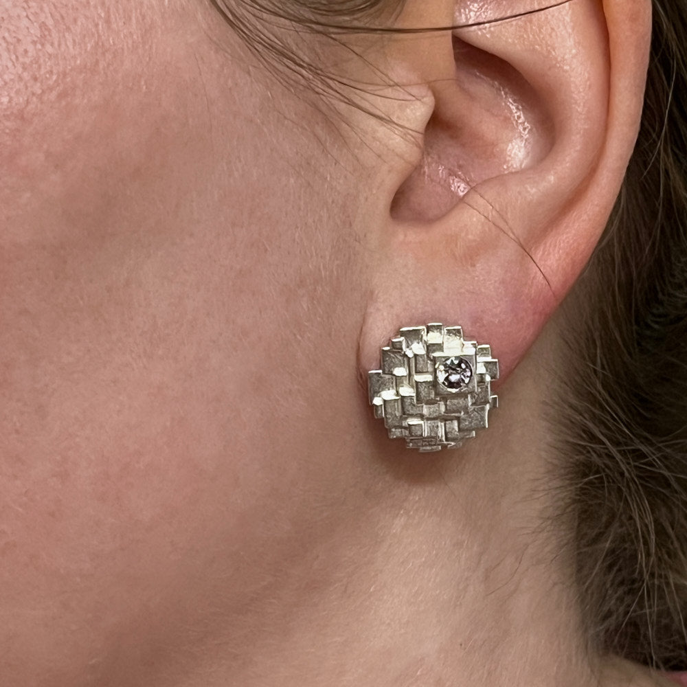 A closeup of a model's left ear wearing a Geode Earring