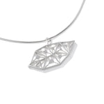 An image of the LīF Necklace, resting at a slight angle against a white surface. 