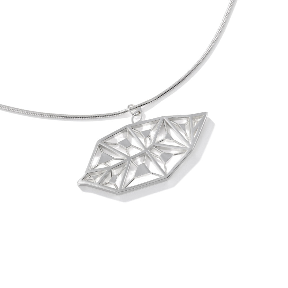 An image of the LīF Necklace, resting at a slight angle against a white surface. 