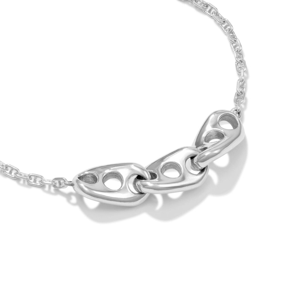 An image of the Seafarer Necklace lying at a 45 degree angle on a white background. The necklace is a stylised vision of the classic marine chain design. With three large, heavy links of sold sterling silver, hanging inline along a more traditional marine chain, this design's simplicity belies its elegance. Three large, solid, twisted links in the center, joined together form a sturdy, rugged chain that still somehow manages to be elegantly refined in its design. 