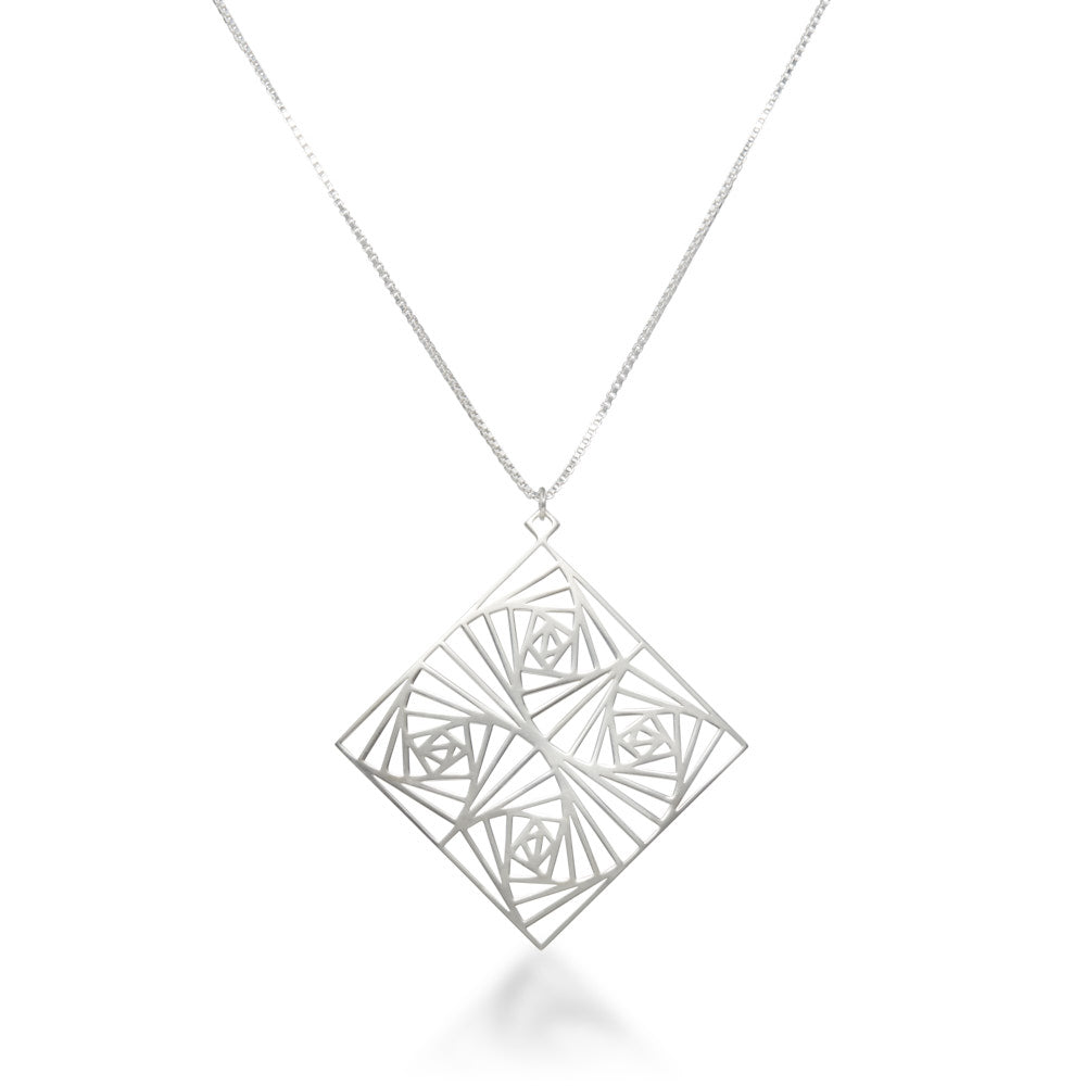 A view of our Square Spiral Medallion hanging head-on over a white background. Inspired by our Square Spiral Earrings, this rather large medallion features a square spiral motif in a repeating pattern, designed with perfect angles at every turn. As about 60mm square, this is a BIG statement piece, but designed to remain lighter than it looks. Hanging from a 22 inch 1.5mm sterling silver Italian box chain, this piece is elegant, powerful, and sure to make a statement.