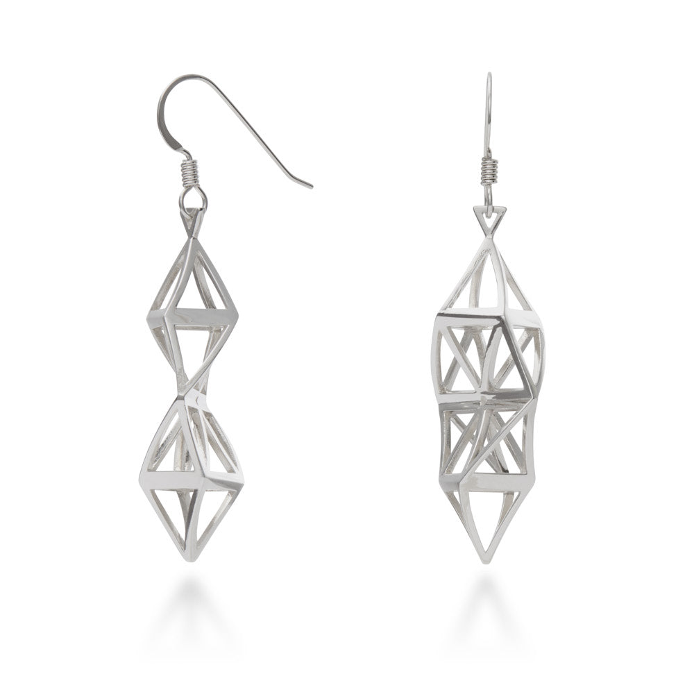 A photo of the Twisted Fractal Earrings. These earrings are a twist of sterling silver scaffolding, built around a central twisted hexagonal shape. They come to point at the top and the bottom, and their triangular bails hang from Argentium hooks added comfort and exceptional tarnish resistance. Each piece twists and sparkles in the light, at once both casual and elegant. 