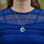 A model in a blue lace-top shirt wears a Hextech Necklace. The model's face is not visible. This is a close up shot of the necklace.