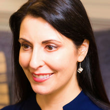 Load image into Gallery viewer, A brunette model wears our sterling silver Tesseract Earrings. This shows a headshot with the earring in her left ear. 
