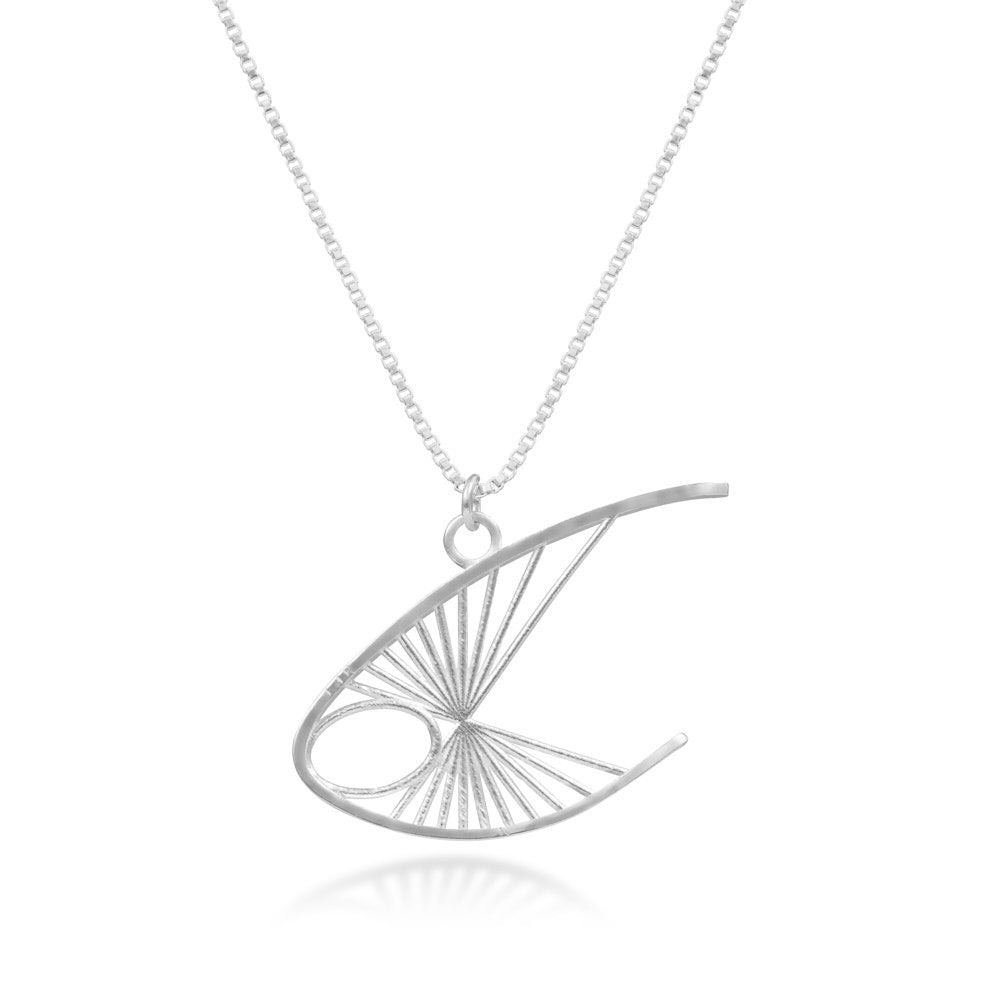 The Curlew Necklace hangs in front of a white background. The pendant is a piece inspired by the Curlew stringed figure sculpture from Barbara Hepworth, itself named for the curlew bird. Growing up, it was a prominent piece in the collection of Neil Ramsay's parents, and has been an inspiration for a great many ideas in the Montgomery-Ramsay jewellery line. This elegant shape in sterling silver hangs from a point along the center of mass that ensures its proper upswept angle.