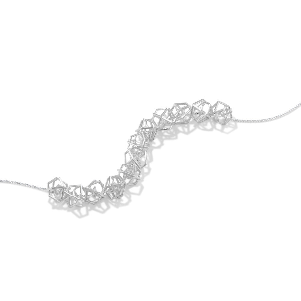 A product photo of our Hexagonal Ice Crystal Necklace lying on a white background. The necklace consists of 12 three-dimensional hexagonal beads strung along a box chain. 