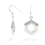 A pair of Stepped Hexagon Earrings hang against a white background. These sterling silver earrings have a modern geometric design featuring rising and falling levels of hexagons. They're 19mm wide and 3mm thick and part of our Stepped Hexagon collection.