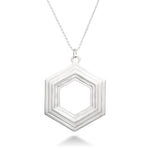 A Stepped Hexagon Necklace hangs in front of a white background. This large sterling silver necklace is a statement piece, comprised of a modern geometric design featuring rising and falling levels of hexagons. Part of our Stepped Hexagon collection.