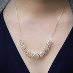 A closeup photo of our Hexagonal Ice Crystal Necklace around the neck of a model. 
